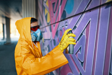 Street artist painting colorful graffiti on wall © GVS