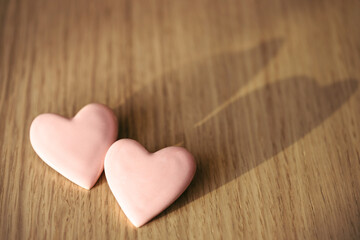 Two pink hearts on wooden table. Valentine's card.