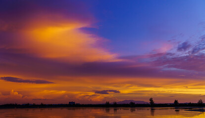 Naklejka na ściany i meble Dusk sky with colorful sunset on sundown in the evening over lake landscape