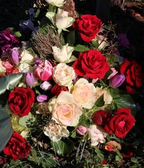 Bunte Blumen im Gesteck als Grabschmuck nach Beerdigung
