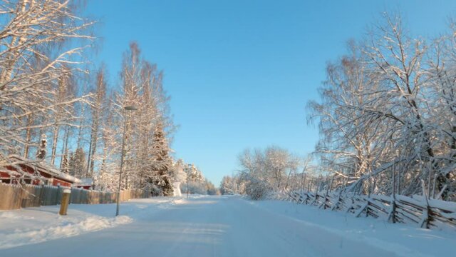 Driving on snowy road through winter landscape, beautiful sunny day.
