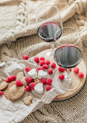 Romantic picnic with red wine, cheese, raspberries, cookies,  on wooven blanket 