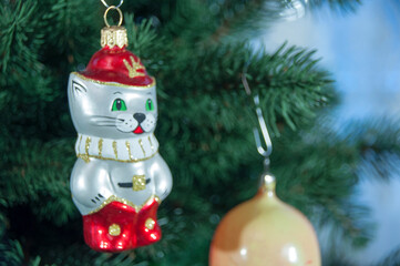 Happy New Year and Christmas. Christmas toy cat in boots on a branch.