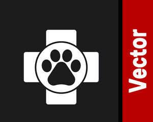 White Veterinary clinic symbol icon isolated on black background. Cross hospital sign. A stylized paw print dog or cat. Pet First Aid sign. Vector.