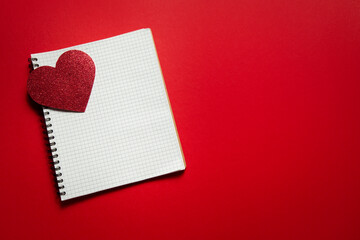 checkered notebook with valentine heart on red background