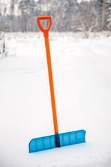 Blue snow shovel. Clearing the site of snow.