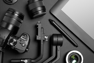 Camera and video production equipment on black background, flat lay