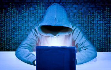 Dangerous hacker behind a laptop screen. Hacking and malware concept, cybersecurity. Digital crimes.