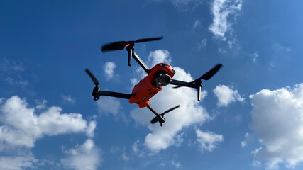 Latest technology RC camera drone or UAV (unmanned aerial vehicle) hovering on deep blue cloudy sky