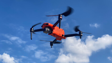 Latest technology RC camera drone or UAV (unmanned aerial vehicle) hovering on deep blue cloudy sky