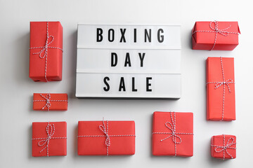 Lightbox with phrase BOXING DAY SALE and Christmas decorations on white background, flat lay