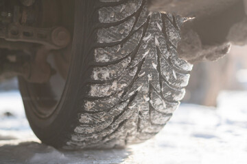 snow and ice winter car tyres. close up auto vehicle wheel