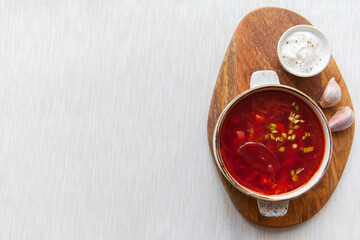 Borscht on a wooden board top view with copy space