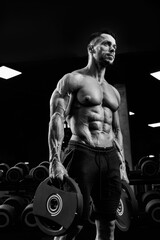 Fototapeta na wymiar Monochrome portrait of bodybuilder carrying weights.