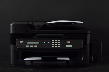 Modern printer with paper on black background
