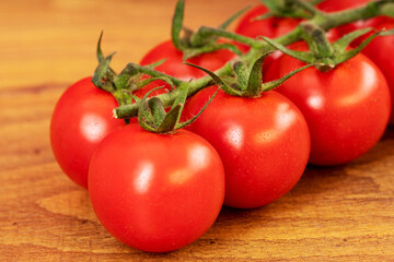 Close up of red cherry tomatoes on a brown wooden table