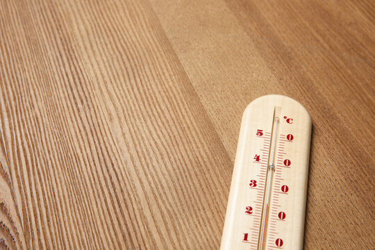 Weather thermometer on wooden table, closeup. Space for text
