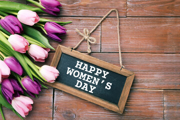 Bouquet of tulips with frame and text Happy Womens Day on brown wooden table