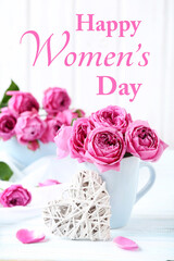 Beautiful pink roses with text Happy Womens Day on a white wooden table