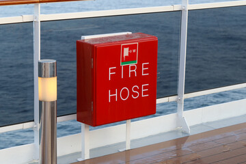 Fire Hose,  rote vier eckige box mit Feuerwehrschlauch an der Reling von grossem Kreuzfahrtschiff
