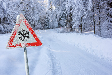 road sign warns of ice and snow at winter