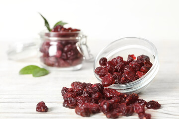 Tasty dried cranberries on white wooden table. Space for text