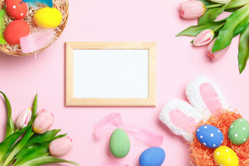 Naklejka na ściany i meble Easter eggs, bunny ears, tulips and frame with copy space on a pink background. Flat lay greeting card.