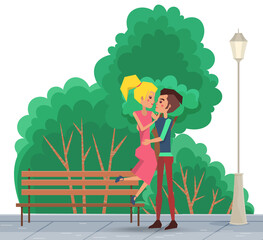 Cute happy smiling couple on a date in the park. The guy picks up the girl in his arms outdoors. People in relationship hugging in the open area against the background of green trees summer day