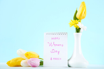 Text Happy Womens Day with tulip flowers on blue background
