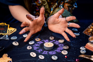 A fortune teller conjures a candle surrounded by runes and the glow of an astrological circle. The concept of divination, astrology and predicting the future