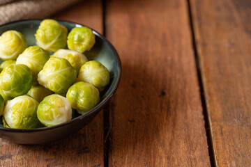 gekochter grüner Rosenkohl in Topf auf einem Tisch aus  braunem Holz in der Küche