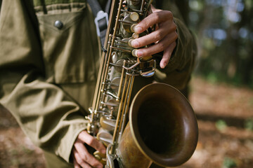 Obraz premium A hand held saxophone in the forest bokeh background