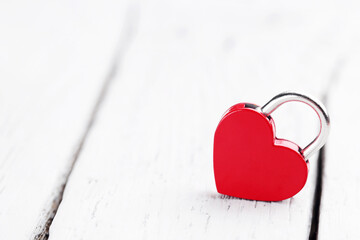 Heart shaped padlock on white wooden table