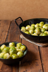 gekochter grüner Rosenkohl in Topf auf einem Tisch aus  braunem Holz in der Küche