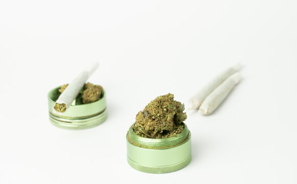 Closeup view of grinder with marijuana buds and joints isolated on white background.Medical cannabis marijuana alternative medicine.Shopping,weed store concept on white background.