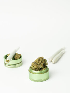Closeup vertical view of cannabis marijuana dry nugs and rolled joints isolated on white background.Medical cbd, hemp and medicine alternative concept.