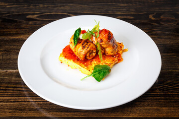 Meat rolls on an omelette with spinach and caramel sauce