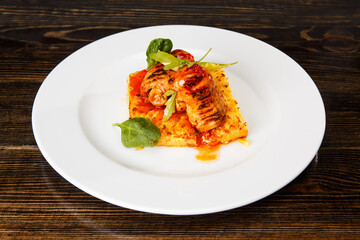 Meat rolls on an omelette with spinach and caramel sauce