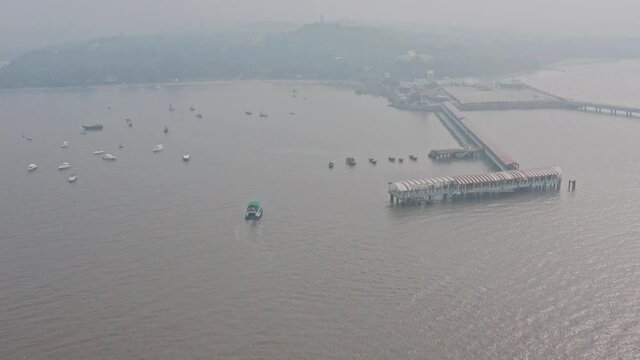 Establishing aerial drone shot towards Mandwa Jetty India on a hazy day