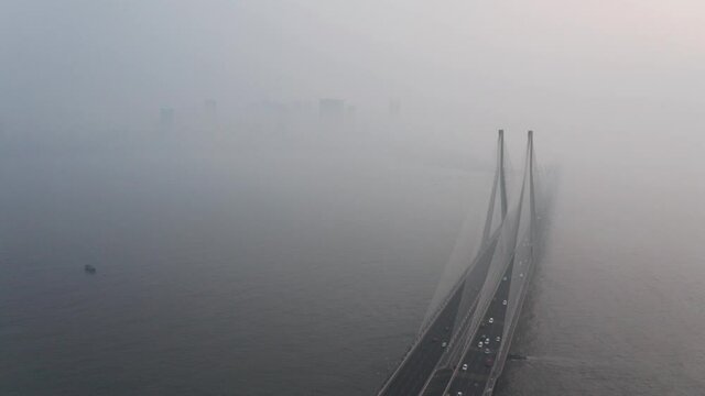 rising drone shot of large suspension bridge bandra worli sealink Mumbai on a hazy day