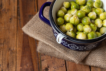 gekochter grüner Rosenkohl in Topf auf einem Tisch aus  braunem Holz in der Küche