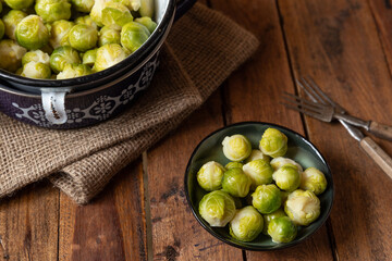 gekochter grüner Rosenkohl in Topf auf einem Tisch aus  braunem Holz in der Küche