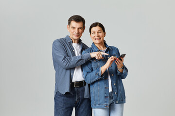 portrait of senor couple with a mobile phone in studio