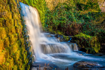 A long exposure side view of a waterfall at Lumsdale on Bentley Brook, Derbyshire, UK
