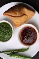 Indian snack Homemade spicy and delicious samosa served with green, tamarind chutney.