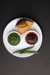 Indian snack Homemade spicy and delicious samosa served with green, tamarind chutney.
