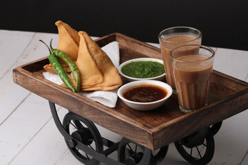 Indian snack Homemade spicy and delicious samosa served with green, tamarind chutney cutting masala...