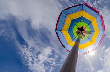 Beach umbrella and sky seen from below