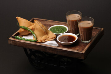 Indian snack Homemade spicy and delicious samosa served with green, tamarind chutney cutting masala...