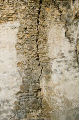 Cracked aged stone wall texture. Textured grunge wall surface background pattern of masonry of old medieval castle